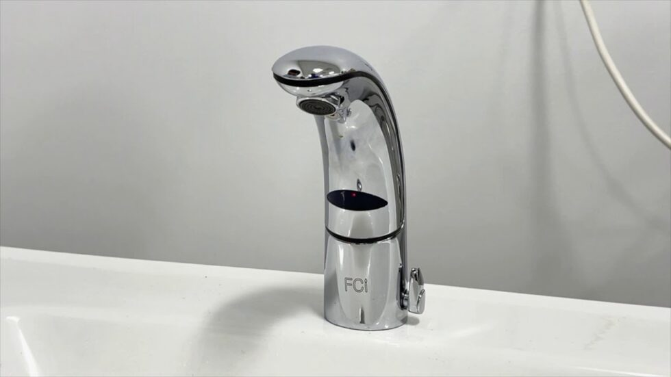 Chrome FCI automatic faucet mounted on a white sink