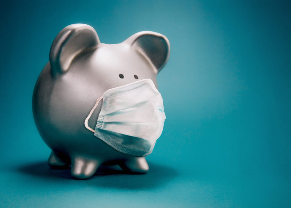 Piggy bank wearing a protective face mask against a teal background